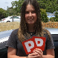 Young lady holding up P plates after passing driving assessment